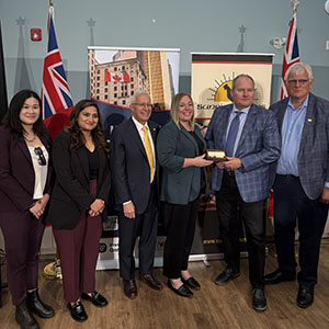 Jane Wang, Priyanka Vaidynath, Minister Fedeli, Heather Potter and Jace Vanover in front of the Invest Ontario Banner.